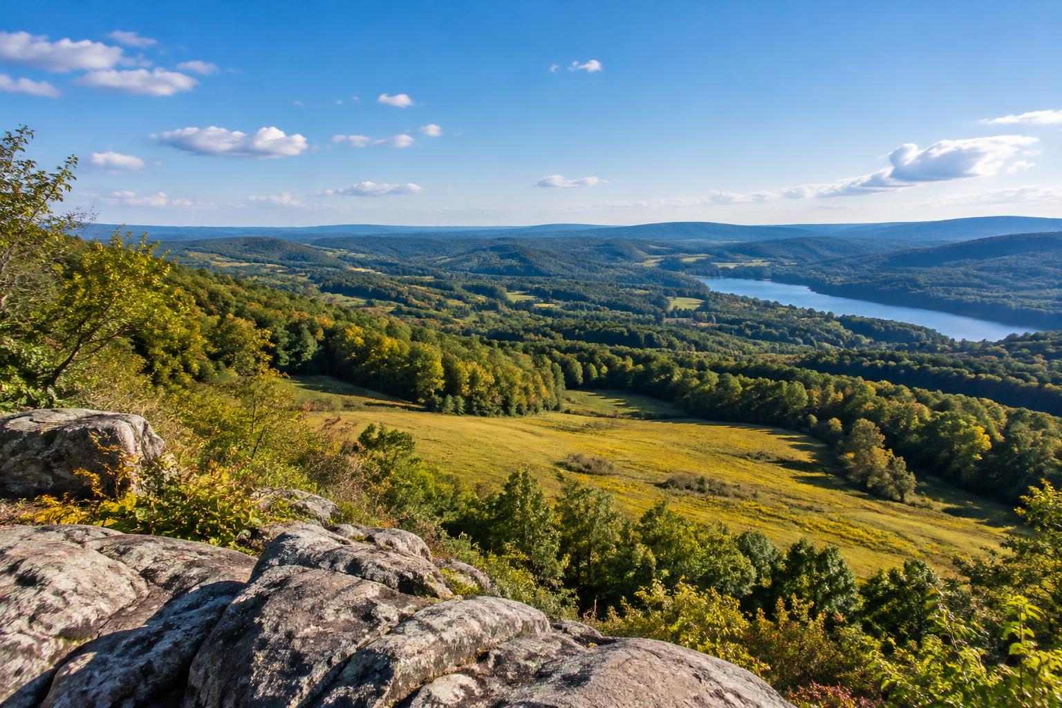 Illustrative New England rolling hills seen from a stone overlook.
